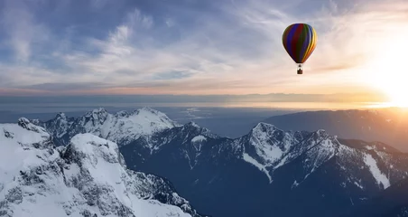 Schilderijen op glas Dramatisch berglandschap bedekt met wolken en heteluchtballon vliegen. © edb3_16