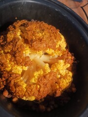 Top view of slow cooked roast cauliflower covered in spices