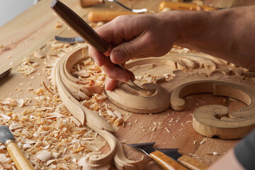 Woodwork and Wood carving. Carpenter's hands use chiesel. Senior wood carving professional during work. Man working with woodcarving instruments