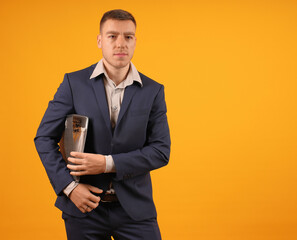 man businessman in suit with folder armpit on yellow background, copy space