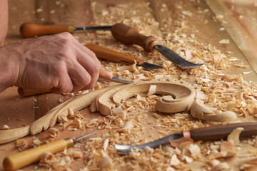 Woodwork and Wood carving. Carpenter's hands use chiesel. Senior wood carving professional during work. Man working with woodcarving instruments