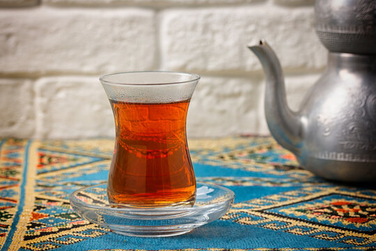 Black tea in armudu glass on wooden background