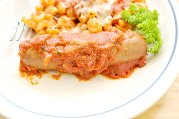 Close Up of a Hot Spicy Sausage with Pasta in the Background	