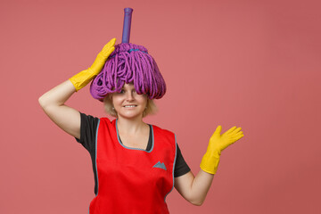Cheerful maid put a mop head on her head