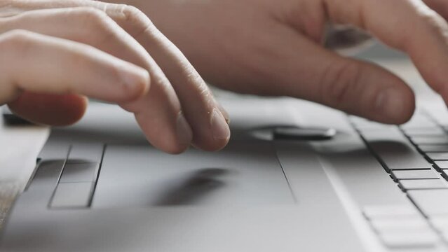 Close-up. Male hands work with the touchpad of a laptop. Input