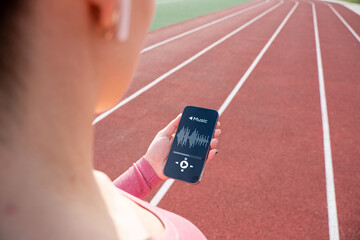 Fitness training music. Girl choose music for running. Lifestyle workout exercise woman training. Fitness, sport, lifestyle concept.