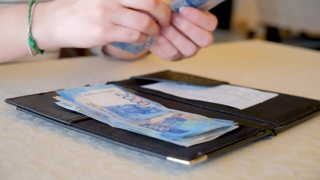 Payment in cash. Rich girl pays an expensive bill from the restaurant with Russian ruble notes. Hands close-up. Bank cards do not work. A visit to the cafe, tips for the waiter.