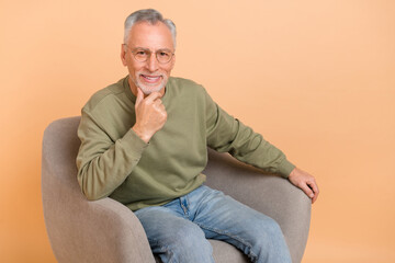 Fototapeta premium Photo of nice old grey hairdo man sit wear pullover jeans isolated on beige background