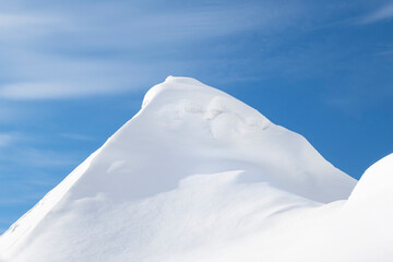 A large pile of snow after a blizzard and snowfall looks like mountain peaks.