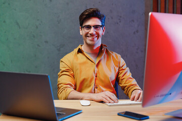 Young fun confident employee programmer IT specialist business man in casual shirt sit work at...