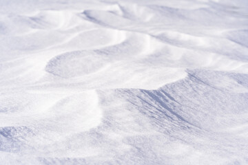 Freshly fallen snow surface looking like dunes shaped by wind. Winter abstract snow texture background.