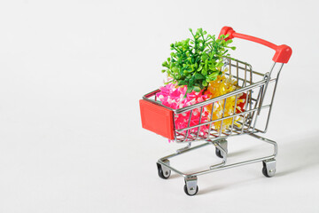 Souvenir toy cart from the supermarket with colorful spring seedlings. The concept of buying seedlings in a store and supermarket. Copy space