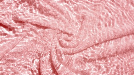 Fototapeta na wymiar Pink terry towel background with water ripples over it | Beauty product background shot for its advertisement