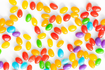 Colorful jelly beans scattered on a white background.
