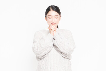指を組んでお願いする女性