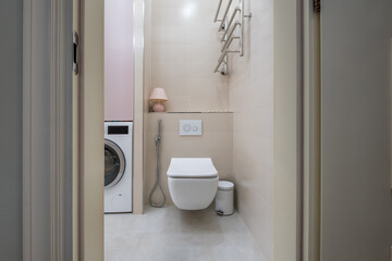 toilet and detail of a corner bidet cabin with wall mount shower attachment