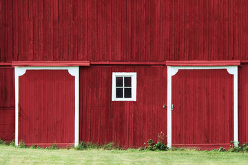 red farm barn hanging doors shadows trees overcast sunny green grass rural farming harvest building - obrazy, fototapety, plakaty