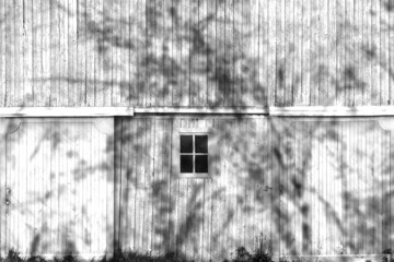 white farm barn hanging doors shadows trees overcast sunny black and white rural farming harvest building