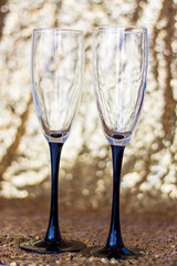 Glasses made of glass with black legs on a shiny background. Glitter background