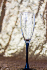 Glasses made of glass with black legs on a shiny background. Glitter background