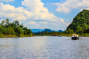 Fototapeta premium Tourists Enjoy the Boat Ride through the Limestone Mountains the Perfume Pagoda outside of Hanoi, Vietnam