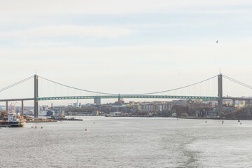 View of magnificent Älvsborgsbron bridge in Gothenburg as viewed from the passing ship. Cloudy overcast day.