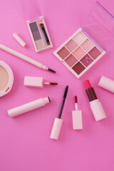 Obraz na płótnie Canvas A set of makeup tools placed on a pink background