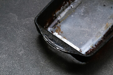 Dirty baking dish with a thick layer of carbon. Glassware for baking with soot, carbon deposits, old dried fat.