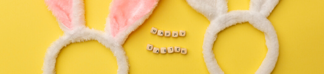 Banner. Bunny rabbit ears and Text Happy Easter on yellow background. Easter minimal concept. Flat lay
