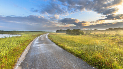 Naklejka premium Hazy Sunset over walking track in the dunes