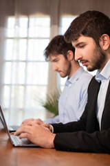 deux jeunes employés de bureau ou hommes d'affaires travaillent ensemble avec des ordinateurs portables.