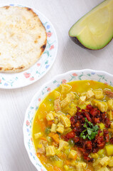 Plate with tripe soup, called mondongo, traditional food from Colombia, South America, on light wood. Also called callos, guatita, tripa mishque, pancita, menudo.