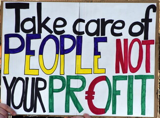 Schild auf einer Demo: "Take care of people not your profit"