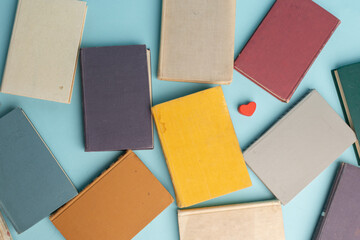 Fototapeta premium Old books on light blue table, top view. World Book Day background