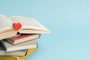 Old vintage books and heart shape wooden piece. World books day