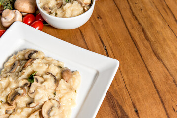 Risotto with mushroom on wooden table.