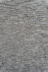 Fototapeta na wymiar Gray brick wall. Background of rectangular gray tiles of different sizes.