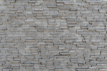 Gray brick wall. Background of rectangular gray tiles of different sizes.