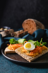 Plate with crispbreads and tasty hummus on dark background