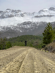 Fototapeta na wymiar adventurer riding a bike with a view of snowy mountains