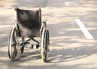 Fototapeta na wymiar Empty modern wheelchair on road outdoors