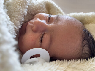 Sweet peaceful baby lying on a white bedsheet enjoy daytime nap