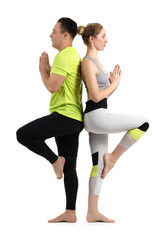 Sporty couple practicing yoga on white background