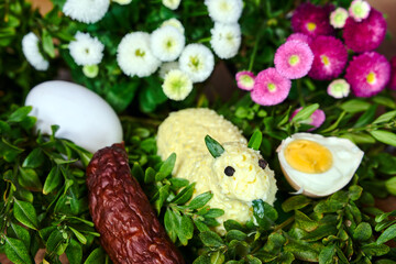 Traditional Easter lamb made of butter, boxwood twigs and colorful spring flowers