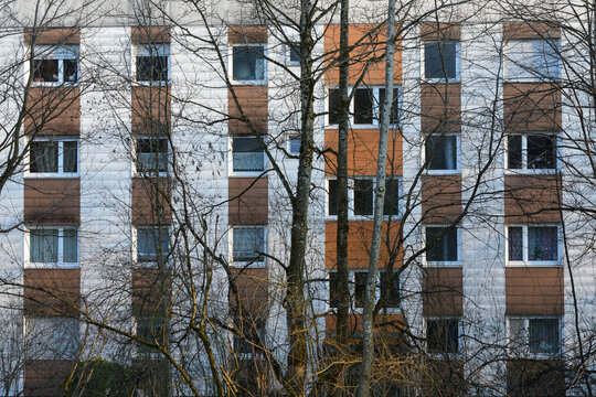 Triste Mietshaus Fassade hinter kahlen B&auml;umen