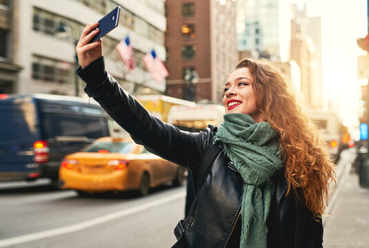 Sharing my location with a picture to go with it. Cropped shot of a young woman taking selfies while out in the city.
