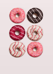 Assorted donuts. Top view photo. Various ring doughnuts with toppings and sprinkles on white...