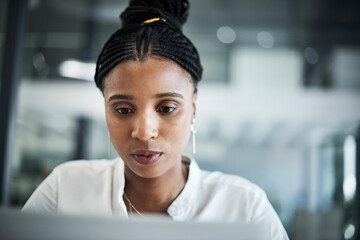 Hustle is part of the journey to success. Shot of an attractive young businesswoman sitting alone in her office and using her laptop.