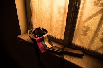 Conceptual photo of war between Russia and Ukraine. Ukraine and Russia flags on windowsill at...