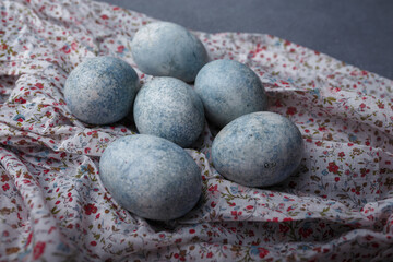 Easter eggs DIY painted blue on grey wooden background with kitchen towel. Close up shot